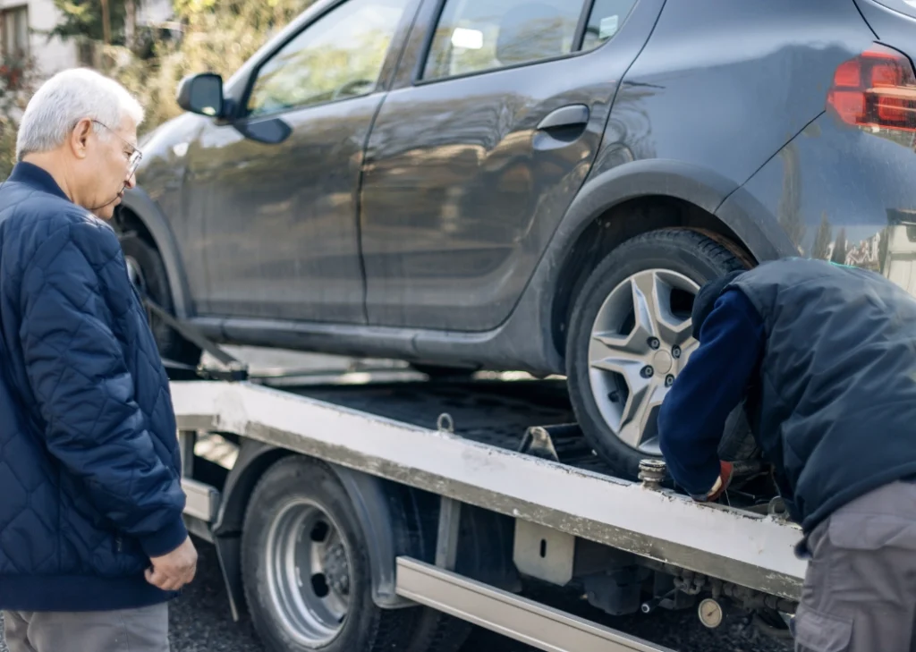 customer waiting as car loaded on tow truck