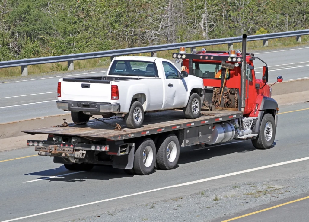 pickup truck loaded onto tow truck flatbed